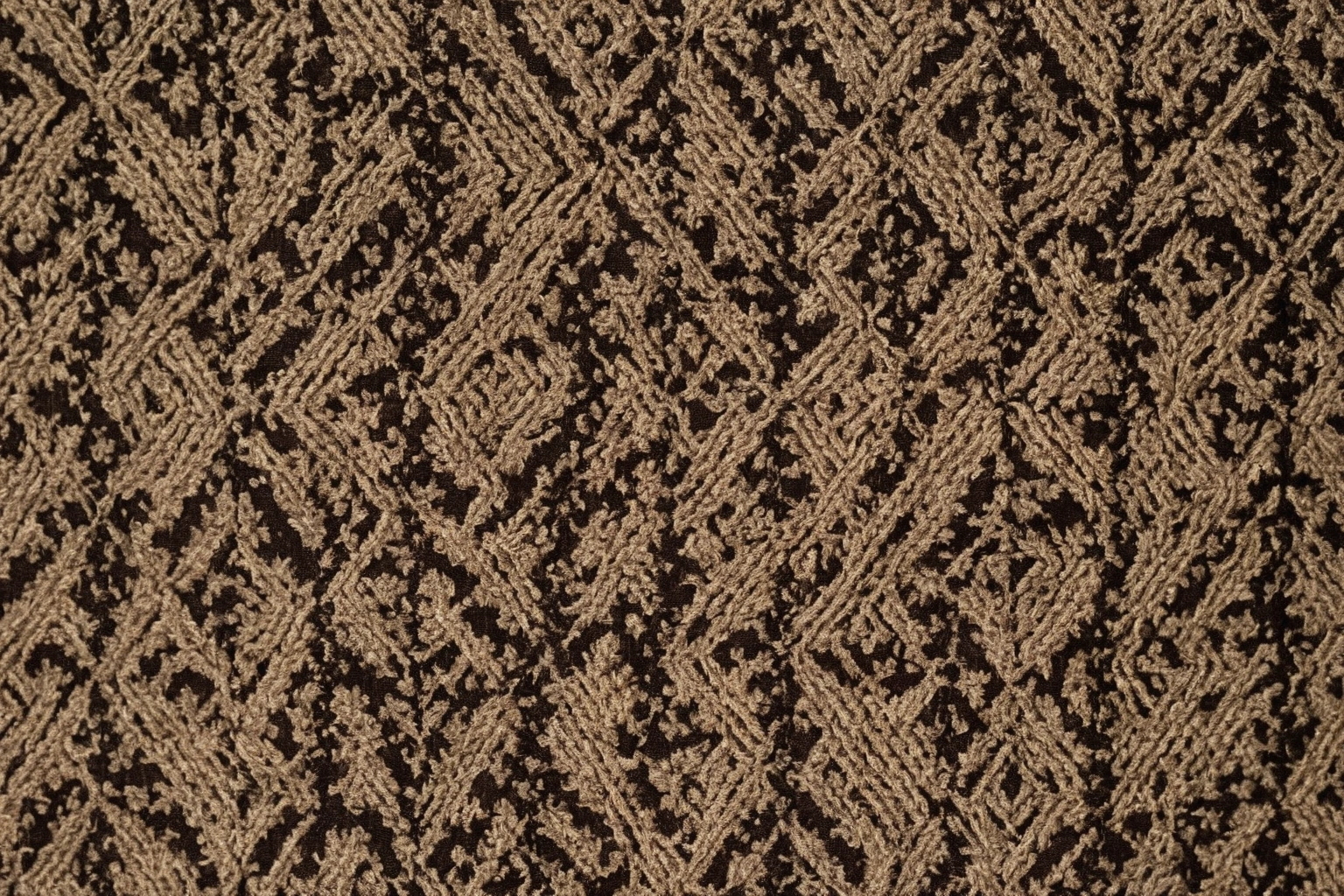 Richly patterned jacquard-woven fabric in warm natural tones, draped to show the woven pattern and thread structure